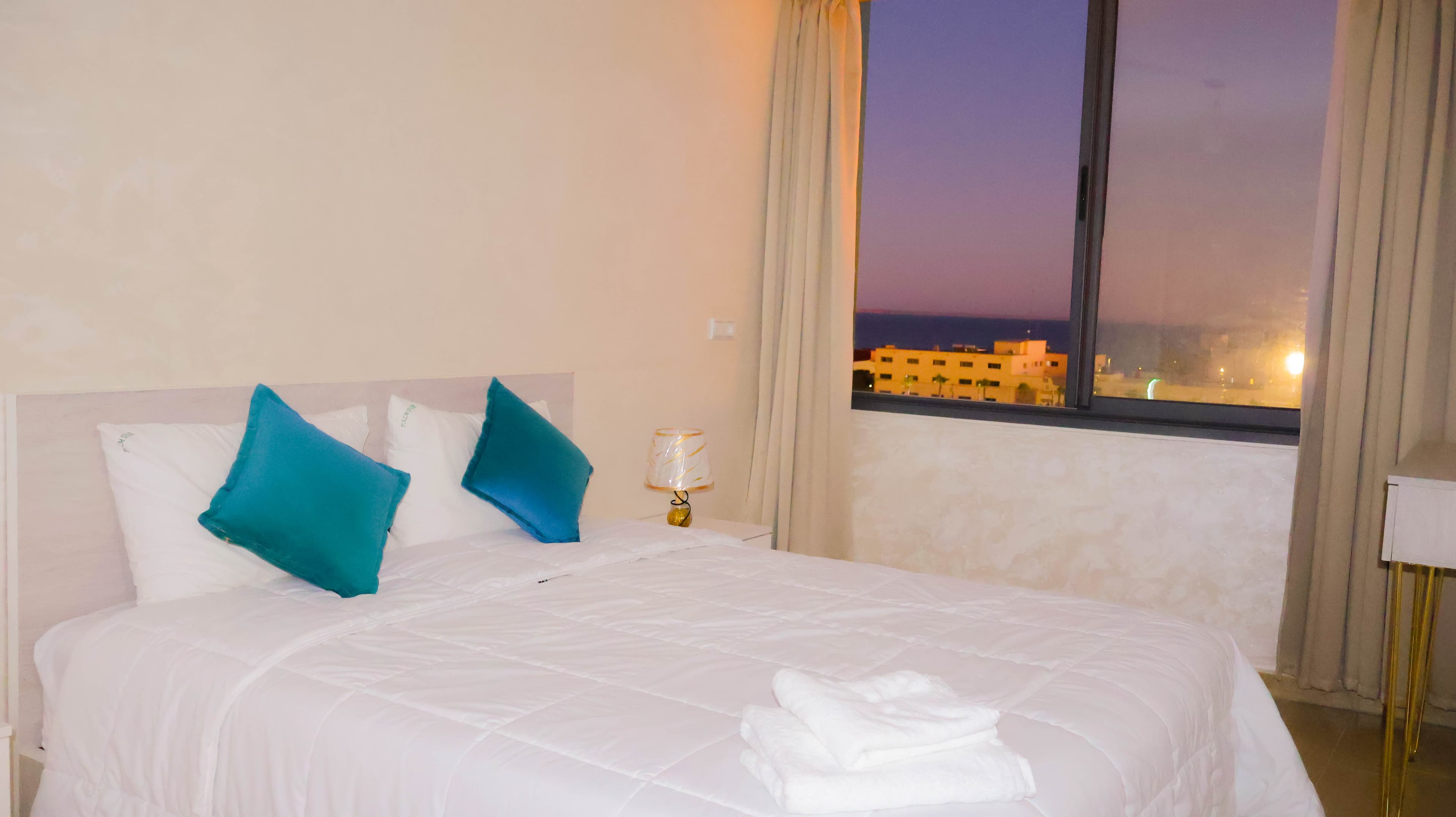 Appartement 1 — chambre avec grand lit et vue nocturne sur Dakhla